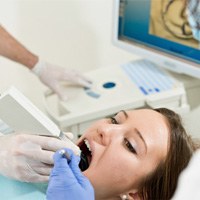 a person having their tooth scanned by a dentist