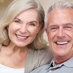 Older couple on couch showing off their dentures