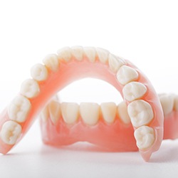 Full set of dentures arranged against neutral background