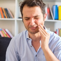 Man suffering dental pain due to gum disease