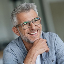 gray-haired man with glasses smiling 