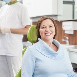 Woman in sweater smiling with dental implants in Midwest City, OK