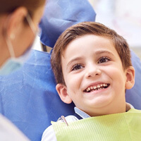 young boy smiling in dental office
