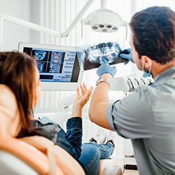 Dentist review X-ray with patient in treatment room