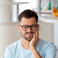 A young man suffering the symptoms of dental implant failure