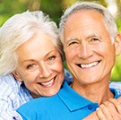 Older couple smiling after restorative dentistry
