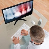 A dentist examining an X-ray prior to tooth extraction