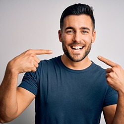 a man pointing at his whitened teeth