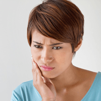 Woman holding jaw in pain before root canal therpay