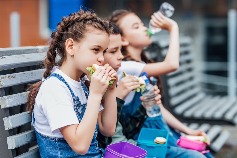 Three children eating their school lunches