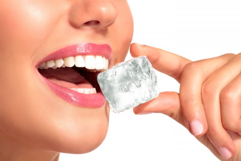an up-close view of a person preparing to bite into an ice cube