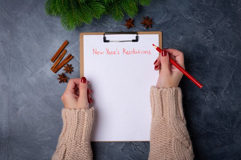 woman writing New Year’s resolutions on paper