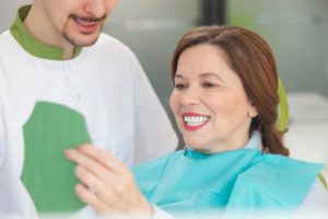 mature woman in dental chair looking in mirror