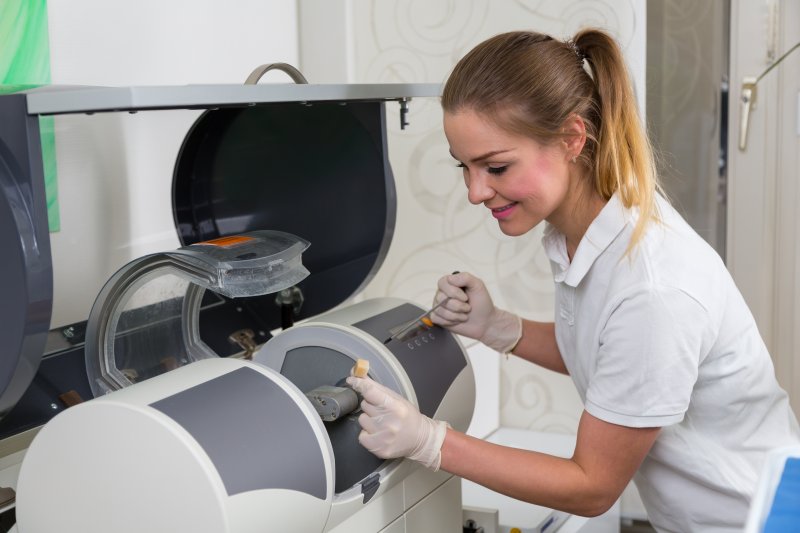 A dentist utilizing a CEREC machine, an advanced piece of dental technology