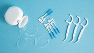 Birds eye view of dental floss and flossers on a light blue background