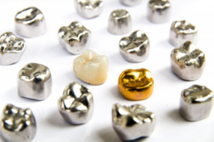 Various types of dental crowns scattered on a white surface