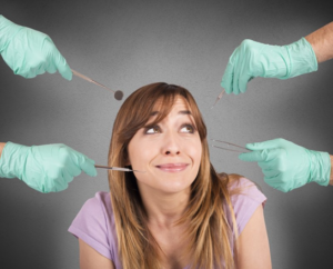 Woman looking nervously at multiple gloved hands that are holding dental tools
