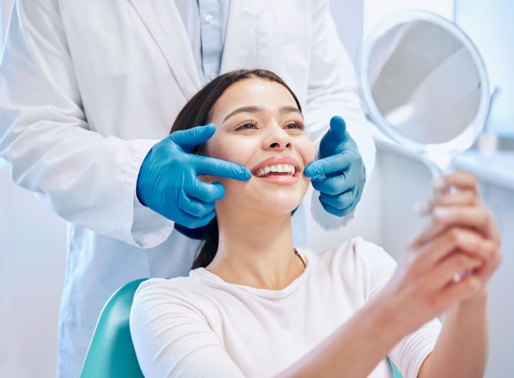 A woman looking at her smile at the dentist’s office